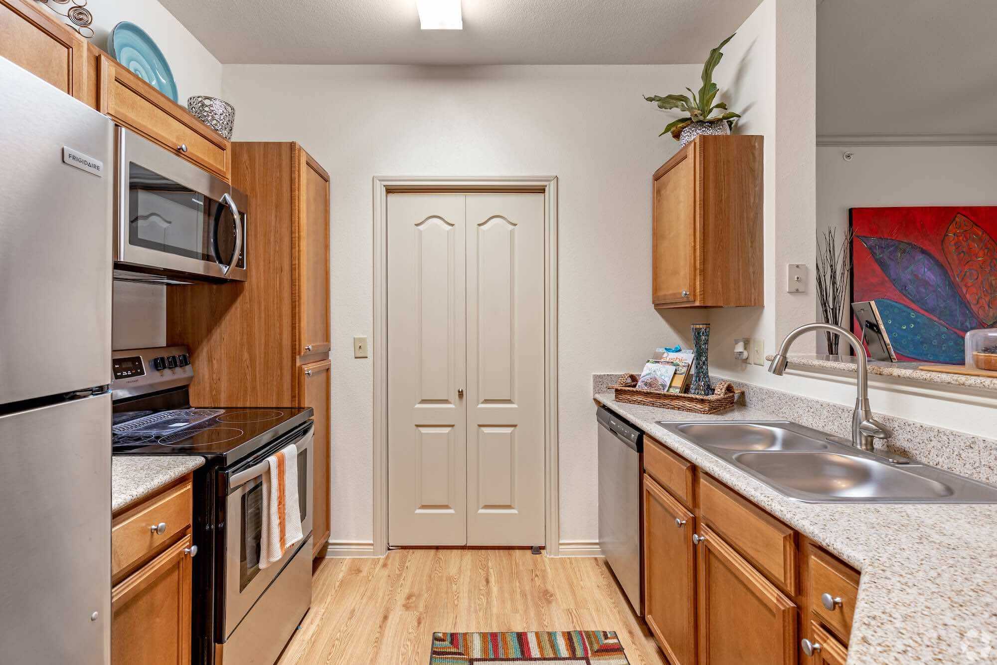 An apartment kitchen with silver appliances.